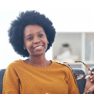 Woman smiling and holding her glasses
